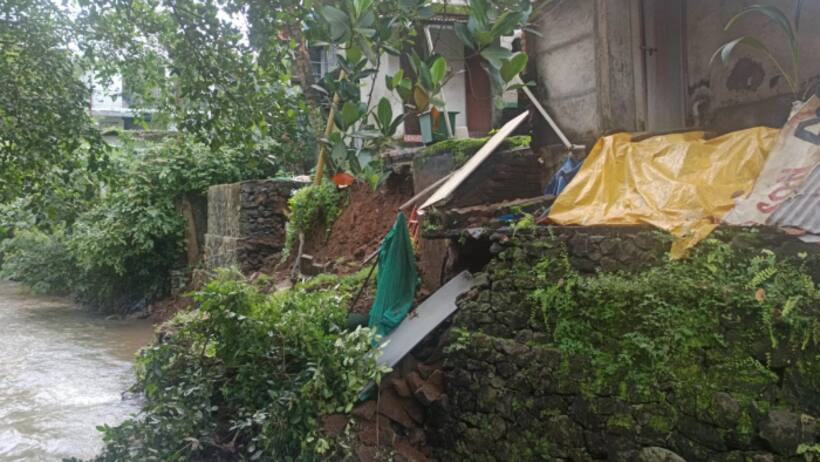ശക്തമായ മഴയിൽ വീടിന്റെ പിൻഭാഗത്തെ മതിൽ ഇടിഞ്ഞ് വീട്ടമ്മ ഉൾപ്പെടെ തോട്ടിലേക്ക് വീണു